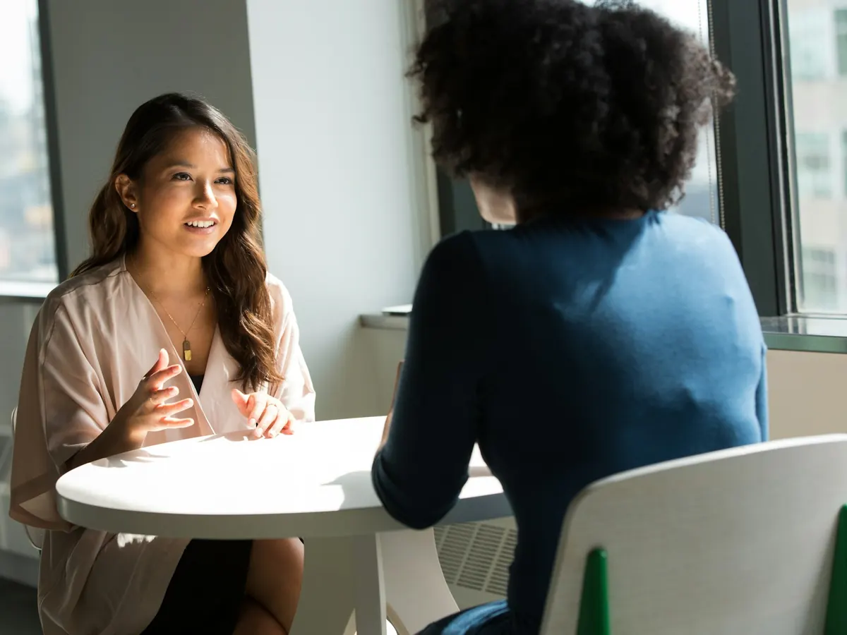 Deux femmes échangent face à face lors d'un rendez-vous.